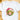 A white short-sleeve crewneck t-shirt laid flat on a light wooden surface, featuring a colorful watercolor graphic of a cute green-haired elf character wearing a pink Santa hat and blowing a pink bubblegum bubble.