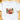 A white short-sleeve crewneck t-shirt laid flat on a light wooden surface, featuring a colorful Christmas-themed graphic that spells 'MAMA' with a reindeer, Christmas tree, red bow, and holiday decorations.