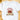 A white short-sleeve crewneck t-shirt laid flat on a light wooden surface, featuring a 'Howdy Christmas' graphic with a pair of decorated cowboy boots and red bows.