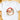 A white short-sleeve crewneck t-shirt laid flat on a light wooden surface, featuring a watercolor-style graphic of Santa Claus's face with a red hat, white beard, and green holly accents.