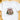 A white short-sleeve crewneck t-shirt laid flat on a light wooden surface, featuring a festive Christmas graphic with the text 'It's the most Wonderful Time of the Year' and a nutcracker snow globe illustration.